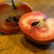 Red love apple cut open into two parts showing the red flesh inside. This was grown by one of DaleysFruit.com.au wonderful customers