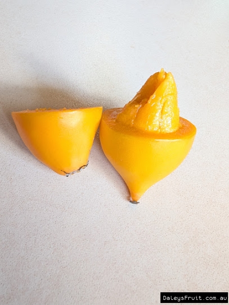 Halved sweet yellow mangosteen showing seed segments inside soft fruit.